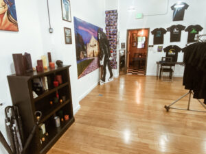 A room with wooden floors and walls, a black shelf on the wall.